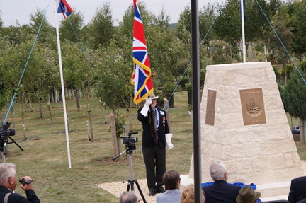 Parry-Jones with ensign next to memorial